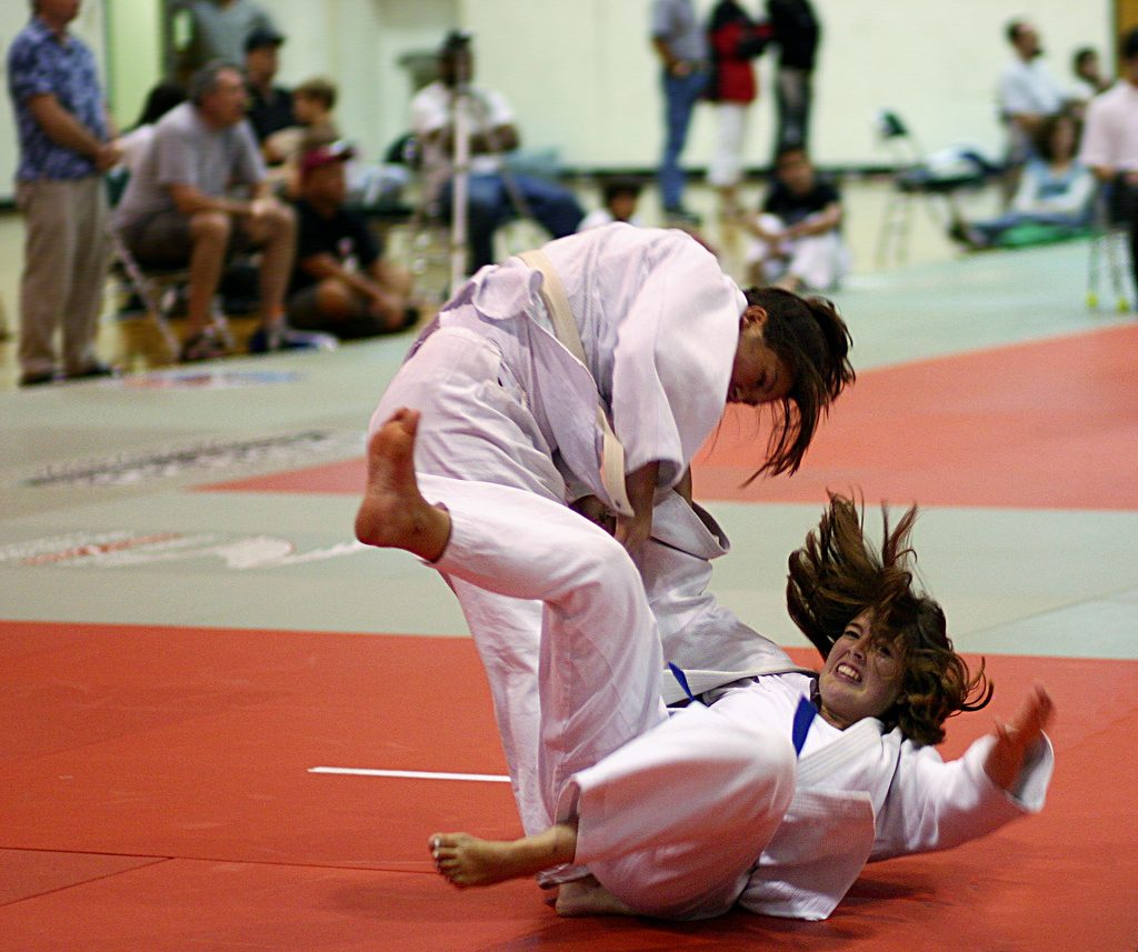 Une judokate en kimono blanc projette son adversaire pour marquer ippon