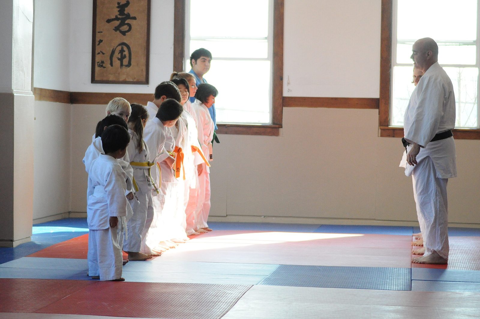 Une rangée d'enfants en kimono salue leur professeur au début du cours