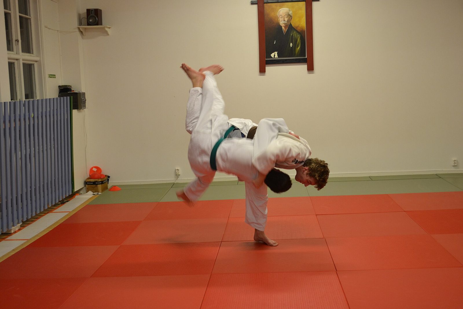 Judoka exécutant un uchi-mata, la jambe de son partenaire levée haut