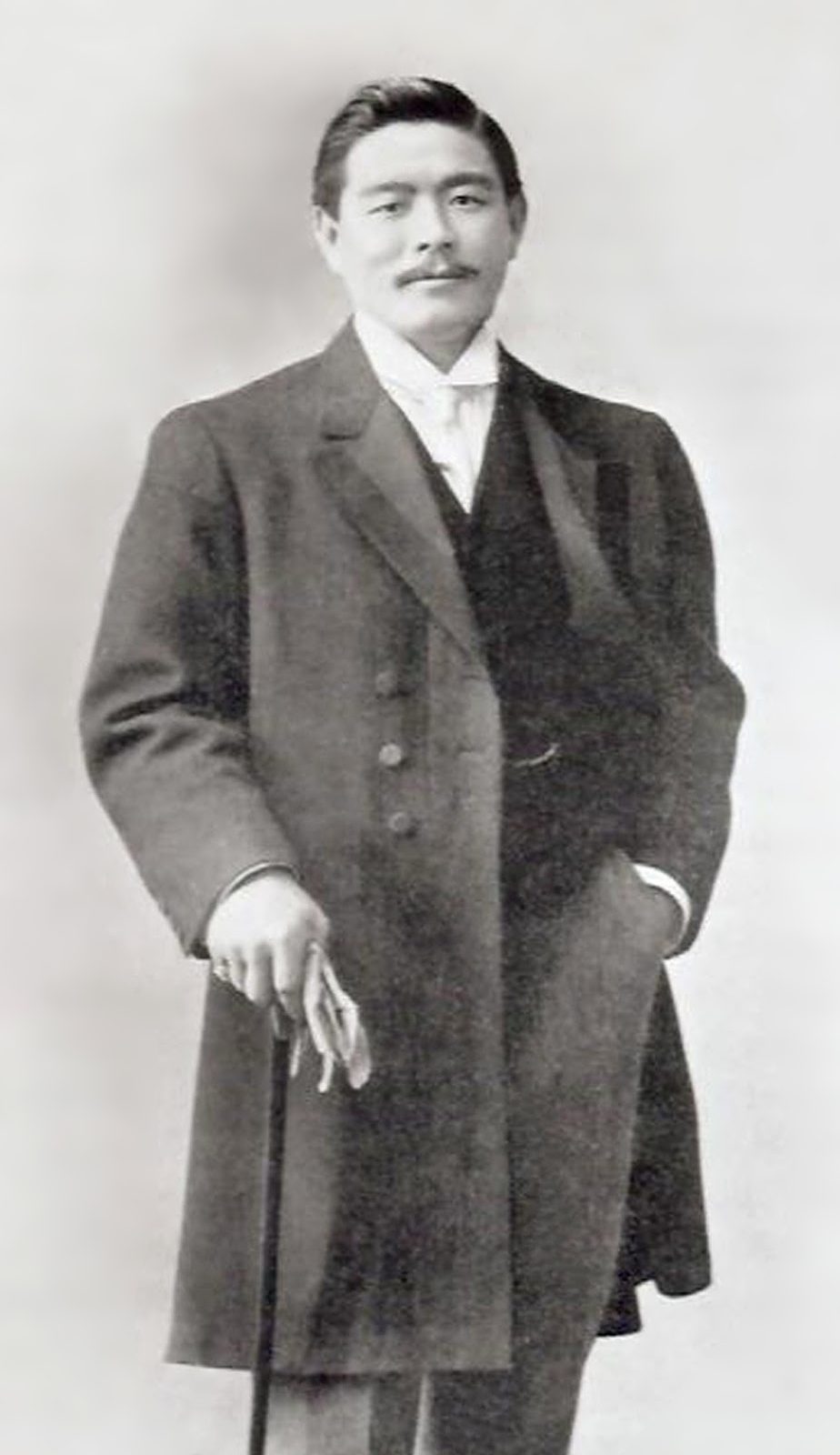 Portrait en pied de Mitsuyo Maeda vers 1910, en manteau et canne à la main