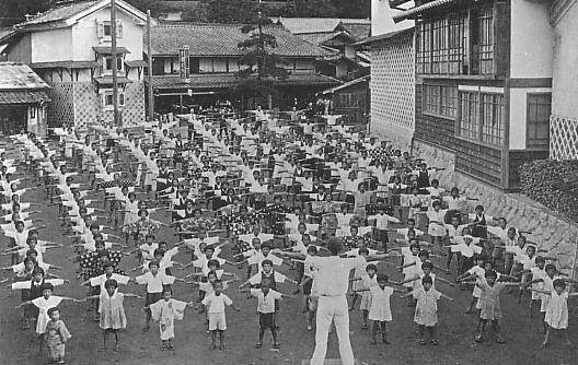 Photo d'archive des années 1930 : des dizaines d'écoliers japonais font la gymnastique en rangs dans une cour